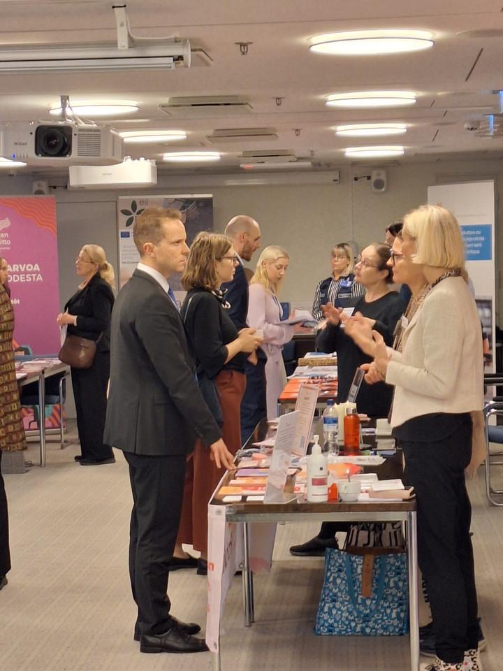 kuva messupöydistä ja ihmisistä